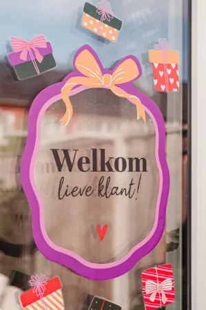Raamsticker met 'Welkom lieve klant' op transparante achtergrond voor winkels.