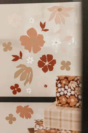 Sfeerbeeld Raamsticker met losse bloemen in wit- en mokkakleuren voor zachte look. Op een raam in de etalage